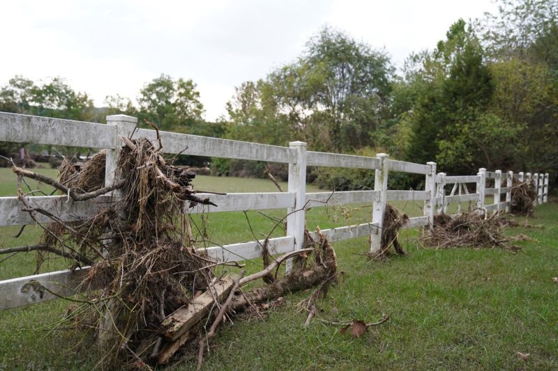 white board fence with debris from Helene